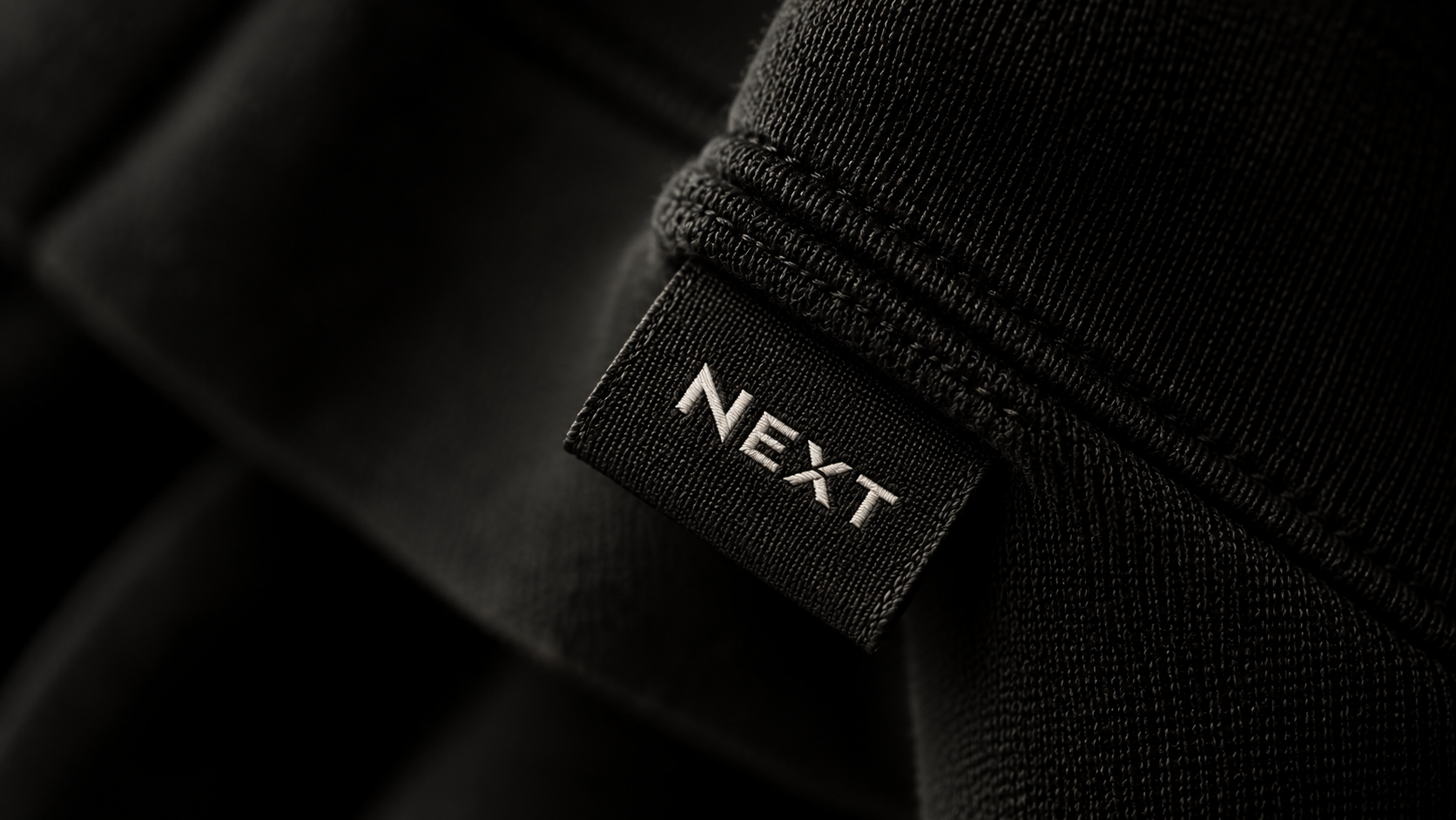 Close-up of the NEXT woven label